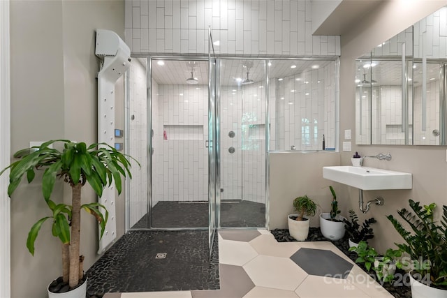 bathroom with a shower with door and sink