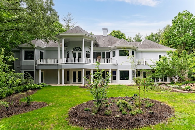 back of house featuring french doors and a lawn