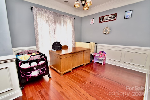 home office with wood-type flooring and crown molding