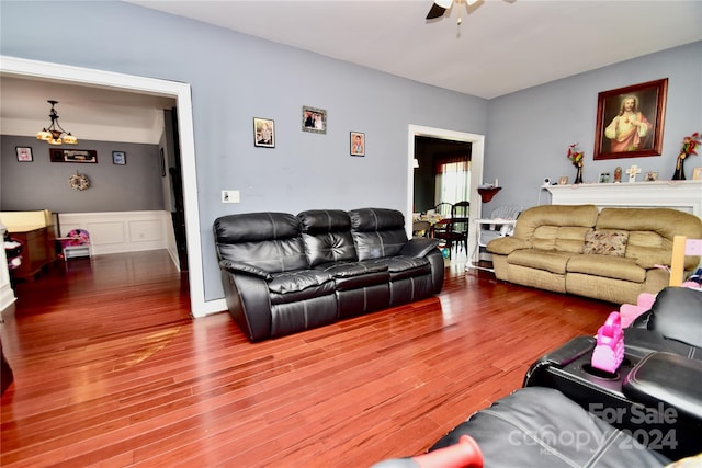 living room featuring wood-type flooring and ceiling fan with notable chandelier