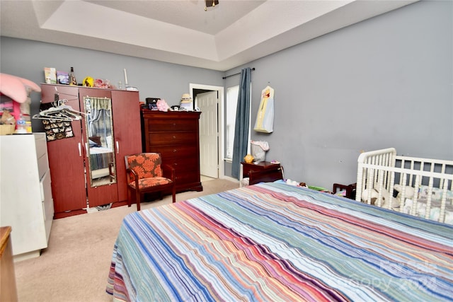 bedroom featuring carpet flooring and a tray ceiling