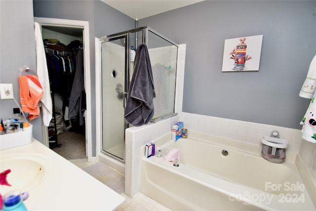 bathroom with tile flooring, sink, and plus walk in shower