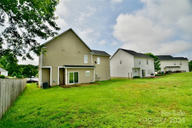 back of property featuring a yard and central air condition unit