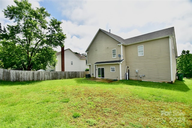 back of house featuring central AC and a lawn