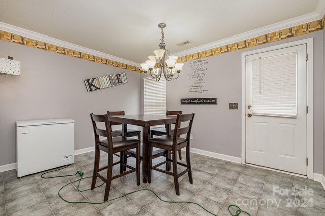 dining area with light tile patterned flooring, crown molding, and an inviting chandelier