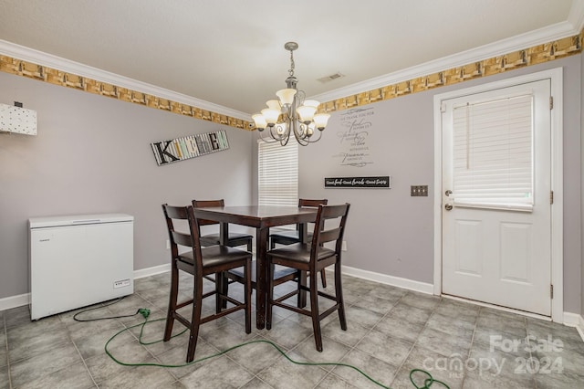 dining room with ornamental molding and a notable chandelier