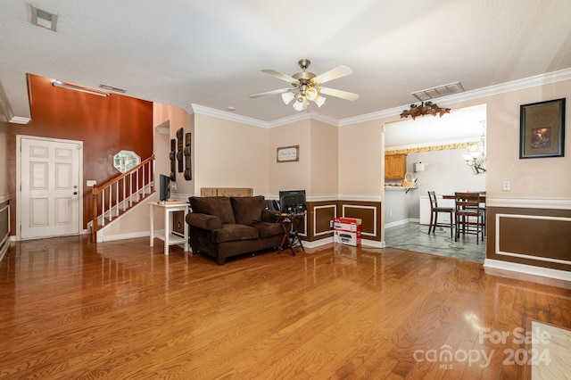 living room featuring ornamental molding, hardwood / wood-style floors, and ceiling fan with notable chandelier