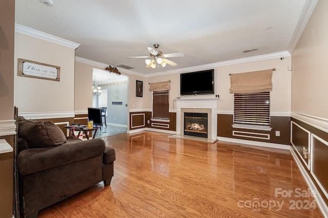 living room with hardwood / wood-style flooring, ceiling fan, and ornamental molding