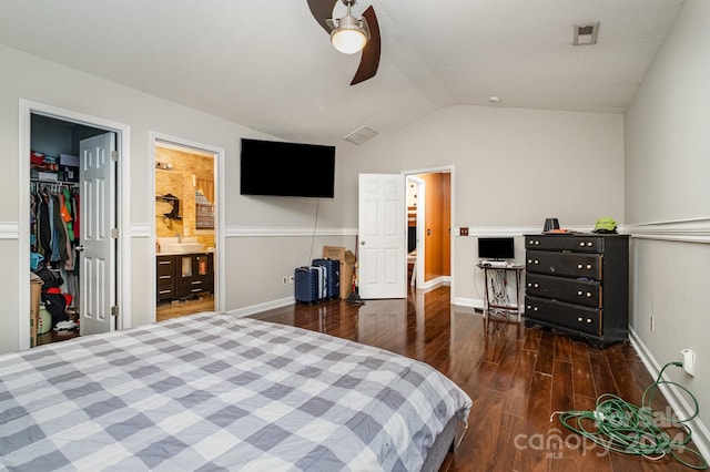 bedroom featuring lofted ceiling, a walk in closet, ensuite bath, a closet, and dark hardwood / wood-style floors