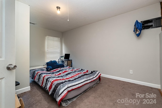 carpeted bedroom featuring a textured ceiling