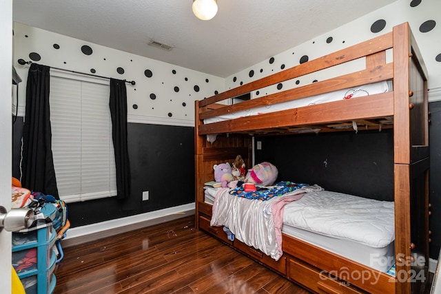 bedroom with dark hardwood / wood-style flooring and a textured ceiling