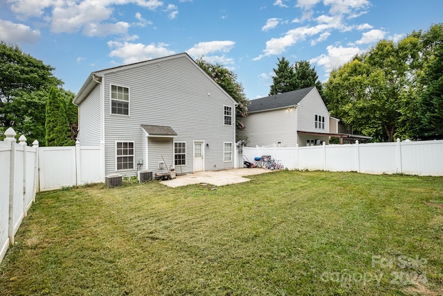 back of house featuring a patio area and a lawn