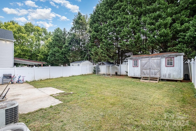 view of yard featuring a storage unit, central AC unit, and a patio area