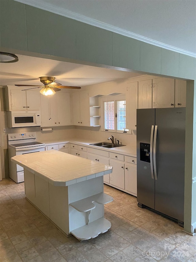 kitchen with ceiling fan, a center island, white cabinets, sink, and white appliances