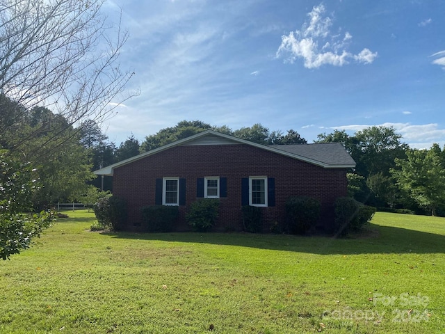 view of side of home with a yard