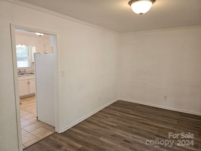 tiled spare room featuring crown molding