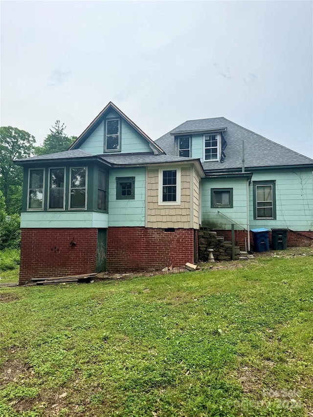 rear view of property featuring a yard