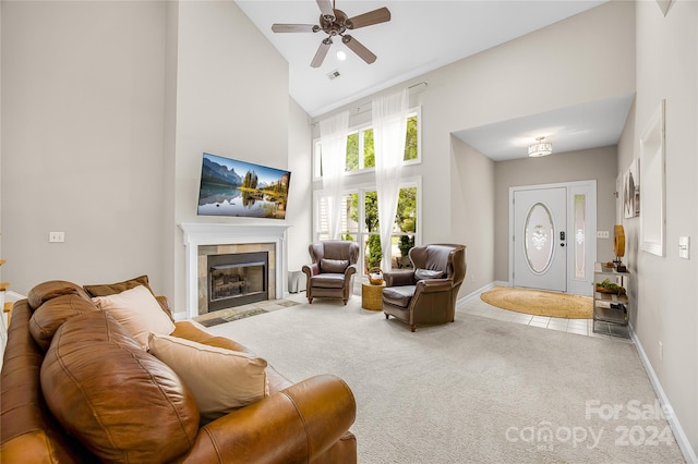 living room with a tiled fireplace, high vaulted ceiling, ceiling fan, and carpet flooring