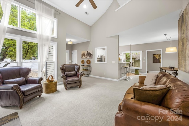 living room featuring high vaulted ceiling, ceiling fan, and carpet