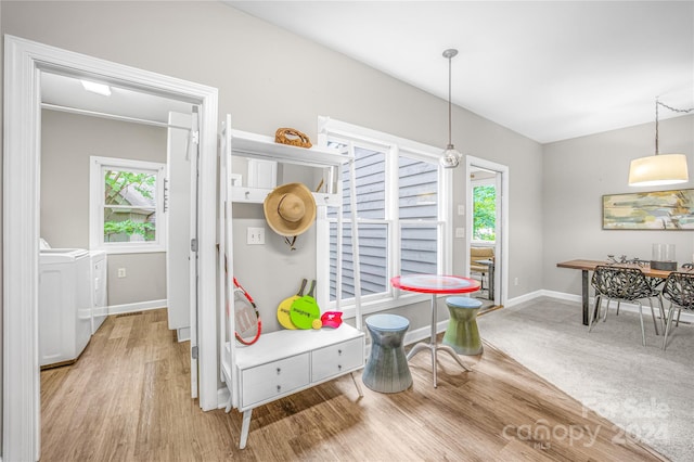 dining room featuring washing machine and dryer and light hardwood / wood-style flooring