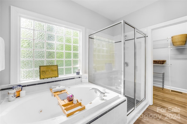 bathroom featuring shower with separate bathtub and hardwood / wood-style floors