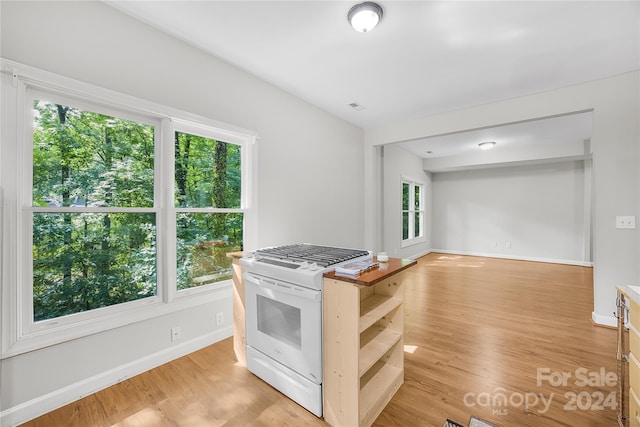 kitchen with white range with gas stovetop and light wood-type flooring