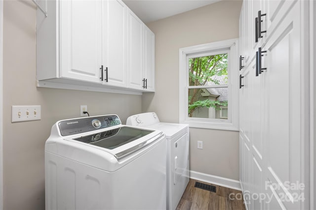 laundry area with cabinets, dark hardwood / wood-style floors, and independent washer and dryer