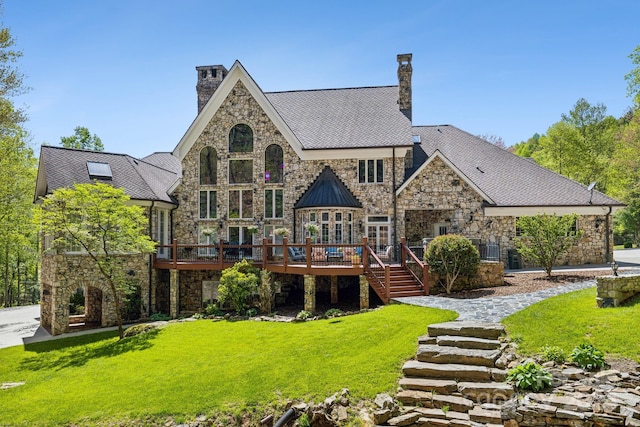 rear view of house featuring a lawn and a wooden deck