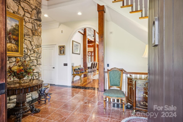 entryway with tile floors and crown molding