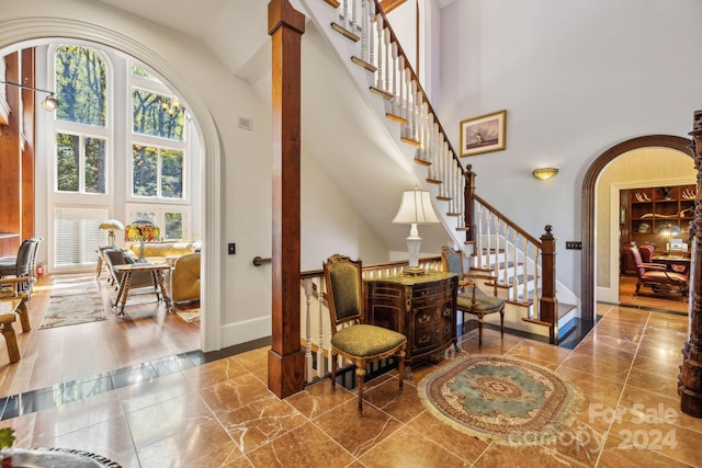 interior space featuring a healthy amount of sunlight, tile flooring, and a high ceiling