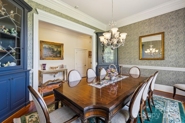 dining area with a notable chandelier, dark wood-type flooring, and ornamental molding