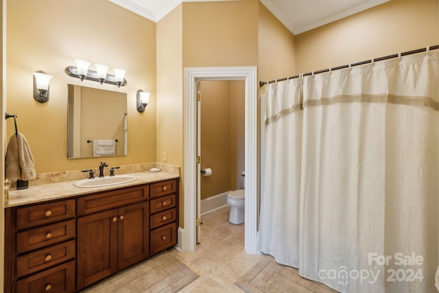 bathroom featuring tile flooring, ornamental molding, vanity, and toilet