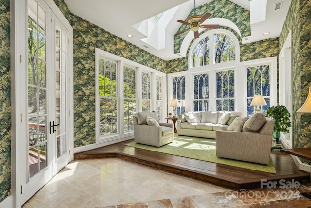 sunroom / solarium with ceiling fan, french doors, and a skylight