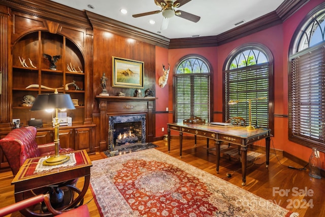 office with hardwood / wood-style flooring, a fireplace, ornamental molding, and ceiling fan