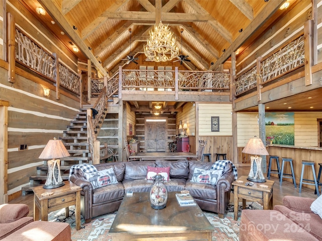 living room featuring wooden walls, a towering ceiling, a notable chandelier, and wood ceiling