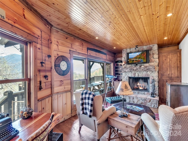 living room featuring a fireplace, wooden ceiling, wood walls, and wood-type flooring