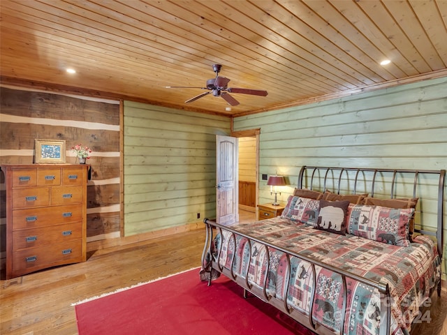 bedroom with wooden walls, wood ceiling, ceiling fan, and hardwood / wood-style floors