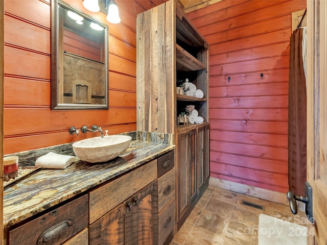 bathroom featuring wood ceiling, tile flooring, wooden walls, and vanity