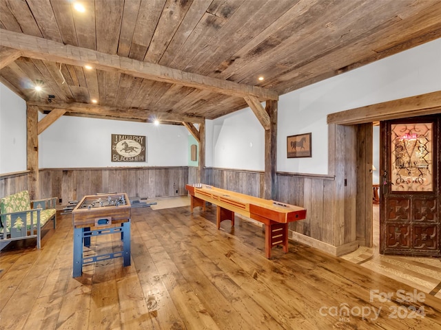 playroom with wooden ceiling, beam ceiling, wood walls, and wood-type flooring