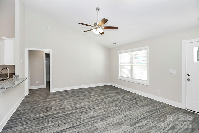 unfurnished living room with sink, dark wood-type flooring, high vaulted ceiling, and ceiling fan