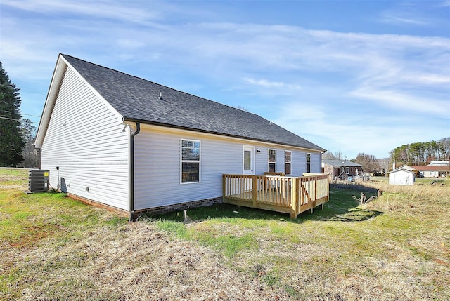 rear view of house featuring a yard, a wooden deck, central AC unit, and a shed