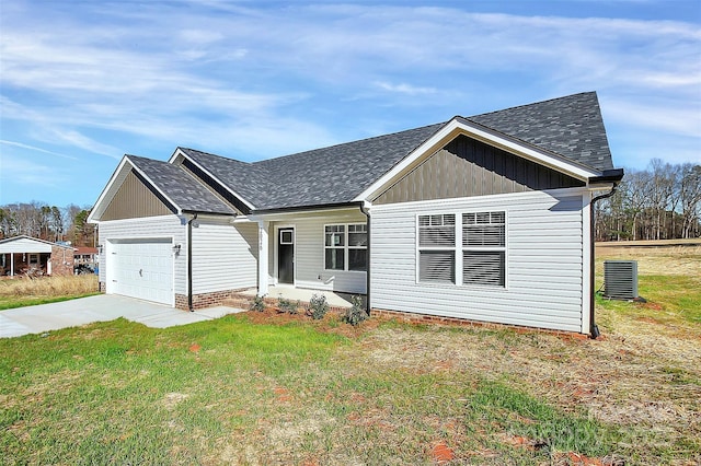 view of front of home featuring central air condition unit, a front lawn, and a garage