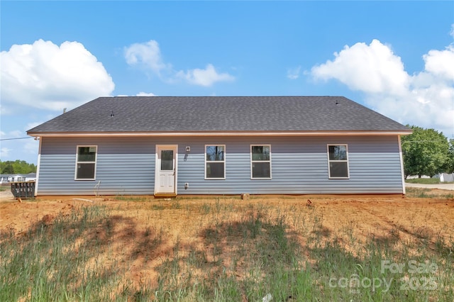 rear view of house featuring a shingled roof