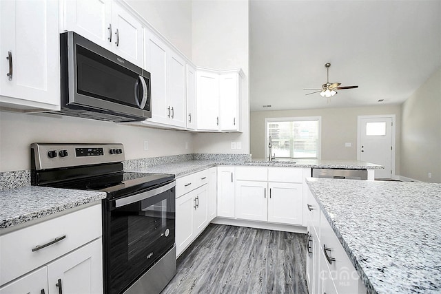 kitchen with white cabinets, stainless steel appliances, a sink, wood finished floors, and ceiling fan