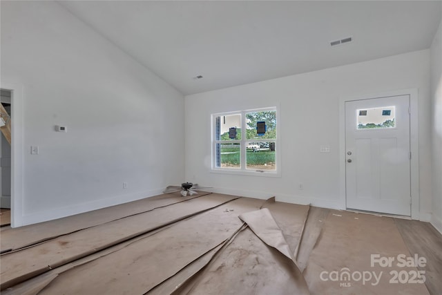 foyer featuring lofted ceiling and visible vents