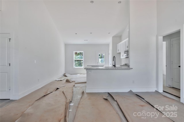 unfurnished living room with concrete floors and a sink