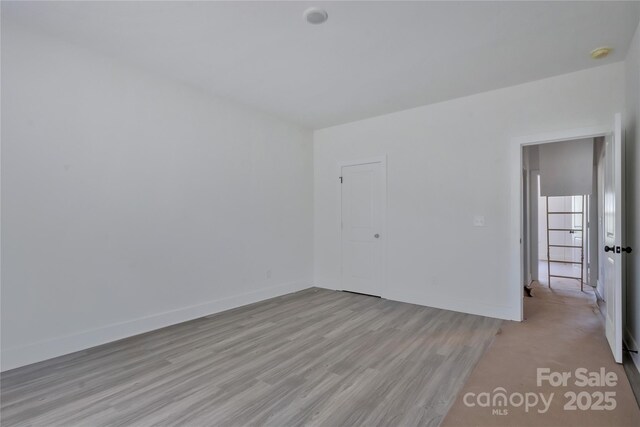 unfurnished room featuring light wood-type flooring and baseboards