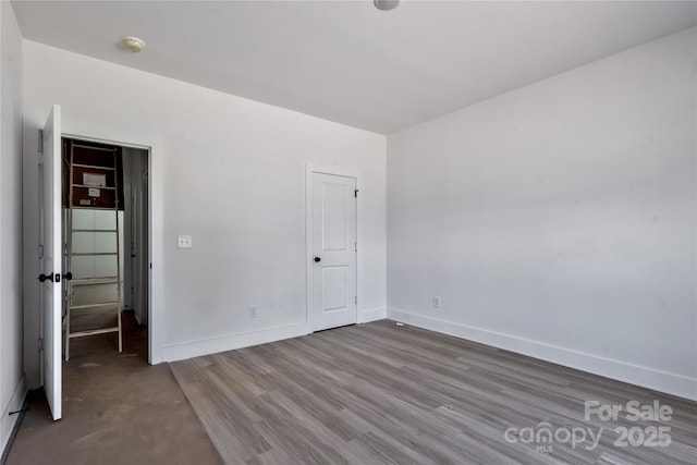 unfurnished bedroom featuring baseboards and wood finished floors