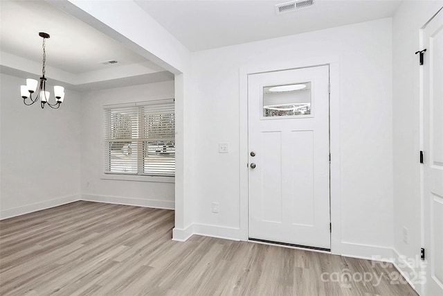 foyer entrance with a chandelier and light hardwood / wood-style floors