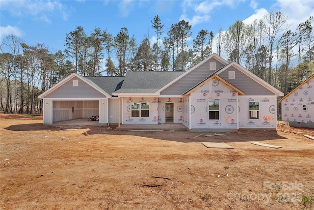 property under construction featuring a shingled roof and an attached garage